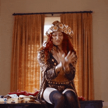 a woman with red hair wearing a hat and stockings sits on a table