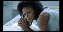 a woman is laying in a hospital bed talking on a cell phone and crying .