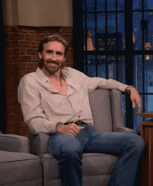 a man sitting in a chair with his arm resting on the arm rest