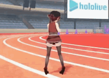 a girl is dancing on a track with a hololive sign in the background
