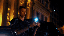a man with a tattoo on his arm is holding a light bulb