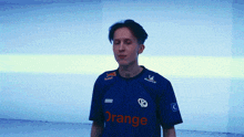 a man wearing a blue shirt with orange on it