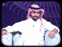 a man with a beard and a head scarf is sitting in a chair with a purple background and the word channels above him