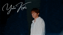 a man is standing in front of a sign that says yuta ishi