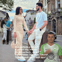 a man wearing a volkswagen shirt is standing next to a woman holding hands