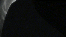 a hand is holding a blue glowing object in the dark .