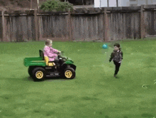 a boy and a girl are playing with a ball in a yard