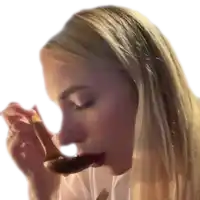 a woman is eating a piece of food with a spoon in her mouth