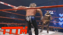 two wrestlers in a ring with the word tim in red