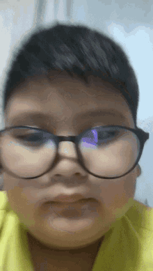 a boy wearing glasses and a yellow shirt
