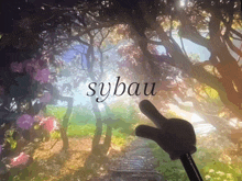 a cartoon hand pointing to the word sybau in front of a forest