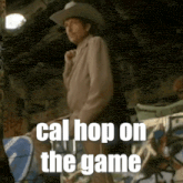 a man in a cowboy hat is standing in a room with the words cal hop on the game written below him