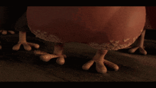 a close up of a chicken 's feet standing on a wooden floor