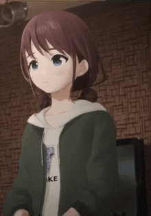 a girl with brown hair and blue eyes is wearing a green hoodie