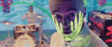 a man with glow in the dark paint on his face is looking at the camera .