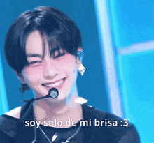 a young man wearing a microphone smiles with the words soy solo de mi brisa : 3 below him