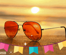 a pair of orange sunglasses on a beach with a coffee please banner