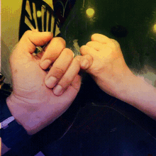 a close up of a person 's hands holding a light bulb