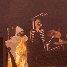 a man in a white hat is playing drums on a stage