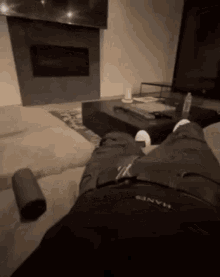 a person laying on a couch in a living room wearing hanes pants