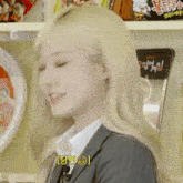 a woman in a suit is standing in front of a shelf with ramen noodles on it