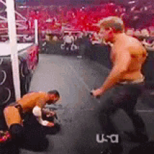 two men are wrestling in a ring with a u-a logo in the background