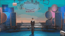 a man stands on a stage in front of a screen that says rthk