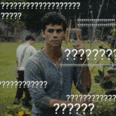 a man standing in a field with a bunch of white letters that say ' ?? '