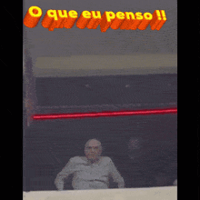 a man is standing in front of a sign that says " que eu penso "