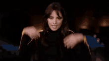 a woman in a black and yellow striped shirt is making a face .