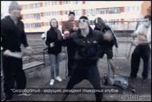a group of people are dancing in front of a building in a foreign language