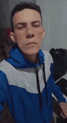 a young man in a blue and white adidas jacket