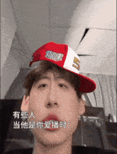 a man wearing a red and white hat with the number 5