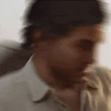 a blurry picture of a man 's face with his hand on his chin