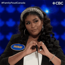 a woman with a name tag that says shenae making a heart shape with her hands