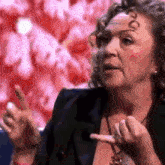a woman with curly hair is making a funny face and pointing her finger