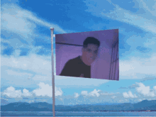 a purple flag with a picture of a man on it is flying in the wind
