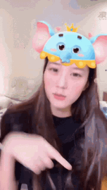 a woman wearing a dumbo mask points to something