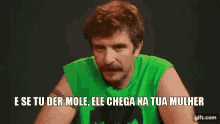 a man with a mustache is wearing a green tank top and says e se tu der mole ele chega na tua mulher