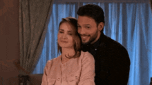 a man and woman are posing for a picture and the woman is smiling