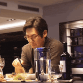 a man sitting at a table with a pitcher of water