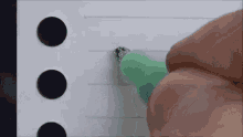 a person is writing on a piece of paper with a green pen .