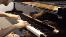 a man playing a piano with the letters yamaha on it