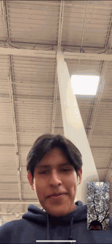 a man in a blue hoodie is on a video call with another man