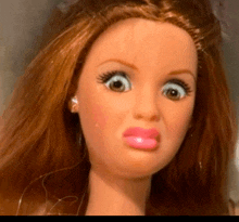 a close up of a barbie doll 's face with a surprised look on her face
