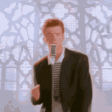 a man in a suit is singing into a microphone