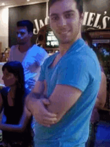 a man in a blue shirt is standing in front of a sign that says jack daniels