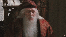 a man with a beard and glasses is wearing a red robe and hat