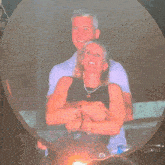 a man and woman are hugging each other in front of a sign that says m