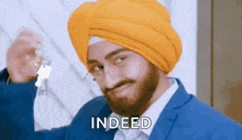 a man wearing a turban and glasses is holding a pair of keys and saying indeed
